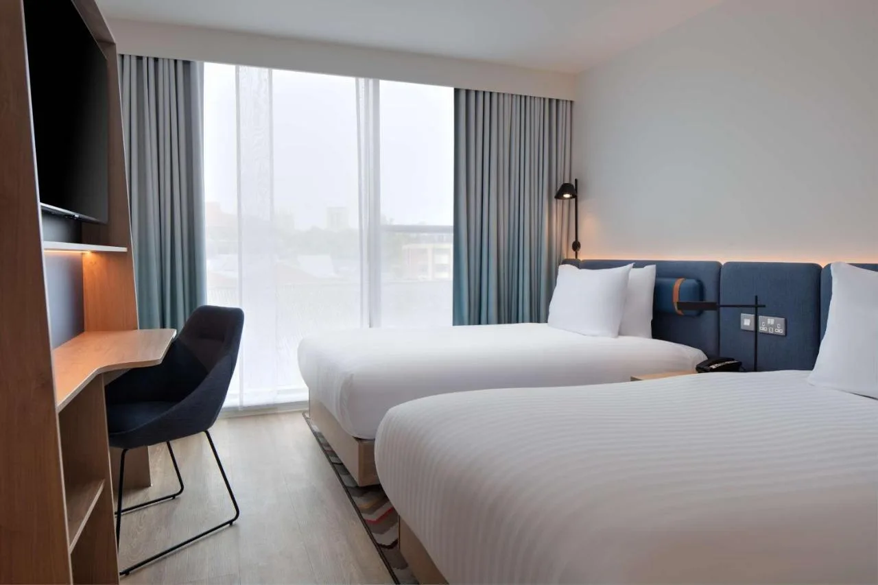Twin hotel room with two beds and a desk at Hampton by Hilton York Piccadilly